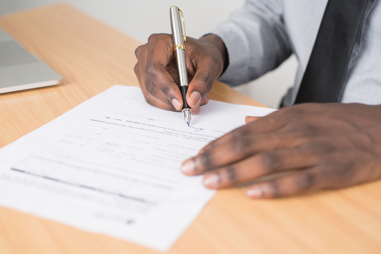 Hand signing documents at an NC attorney closing